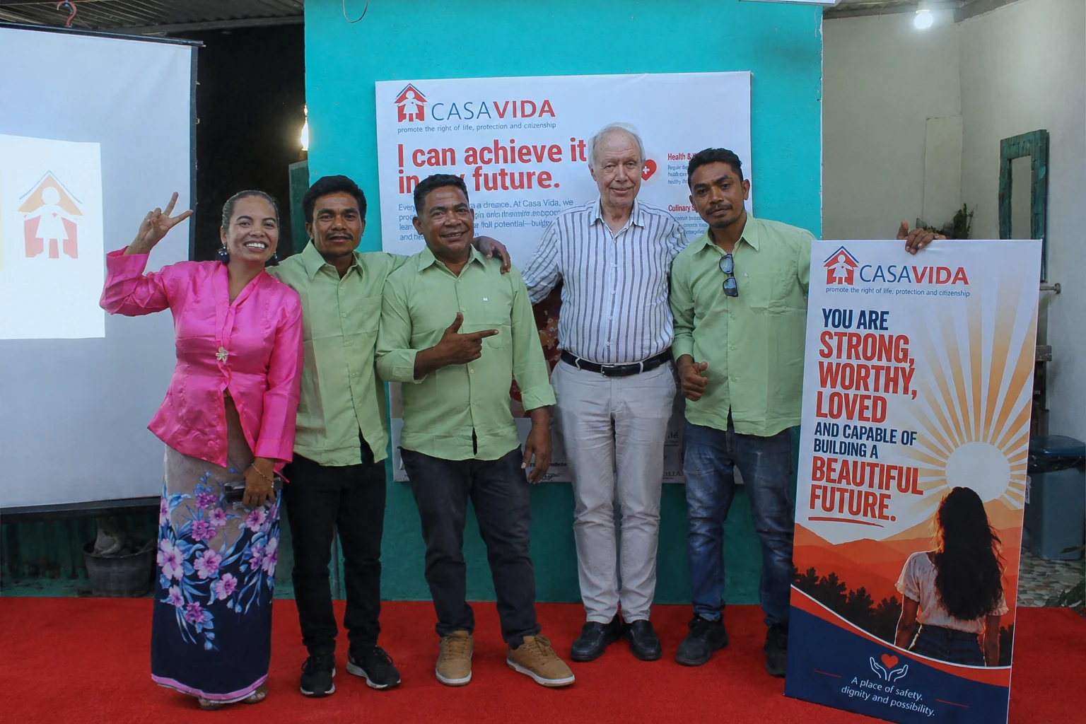 Participants pose together beside a Casa Vida display.